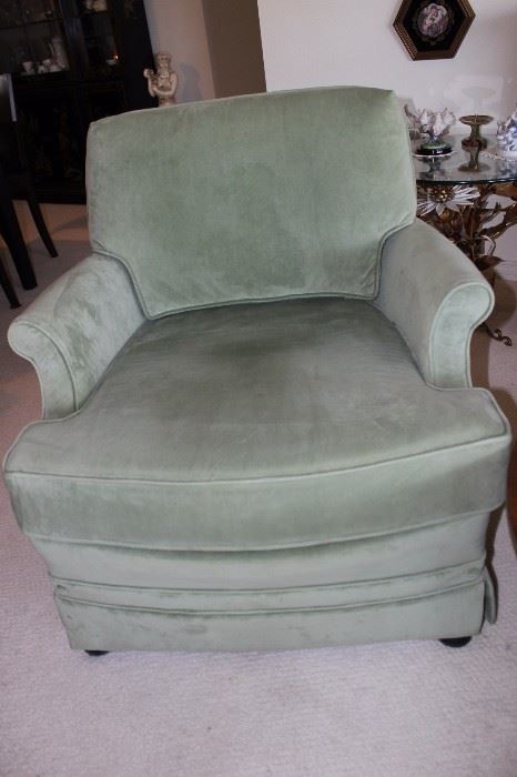 One of two swivel green velvet chairs.