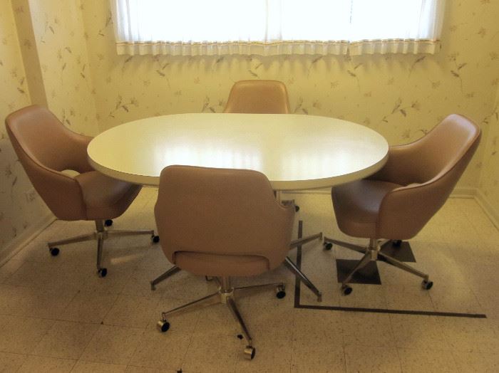 Retro dinette set in great condition.  Oval laminate top table with double metal pedestal base, plus 4 padded, vinyl covered, swivel bucket chairs on wheels.  Table measures 60" x 41-1/2"
