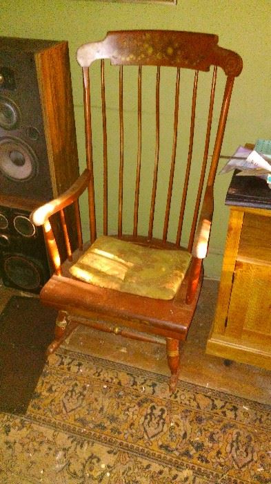 A pair of JBL Stereo Speakers or HiFi speakers. A vintage hardrock maple Rocking Chair. A worn Persian Style Machine made rug. A modern microwave cart on wheels.