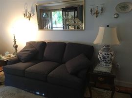 Fabric navy blue couch, large mirror, sconces, lamp
