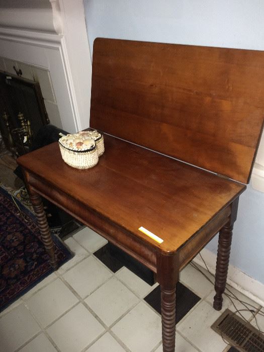 This is an antique  cherry spool leg game table.