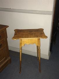 This is a tiger maple stand with spoon feet. and a nicely curved top. This table is about 20 years old however it is much darker than photographed. 