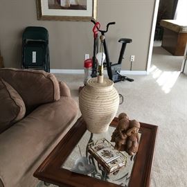 glass/metal side table with beveled glass top and misc. bric-a-brac, pair of lamps, exercise bike, set of folding chairs