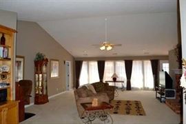 sectional stationary sofa, iron/wood side tables with beveled glass tops, TV stand, and area rug