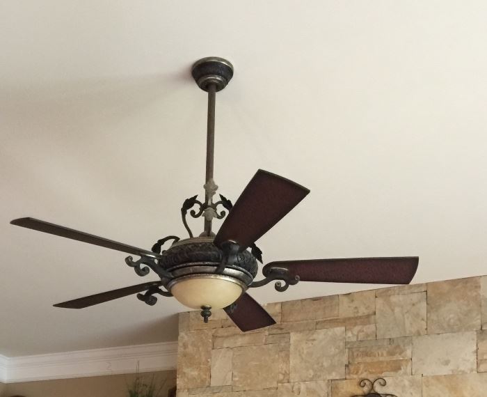 Ceiling fan located in the living room is ornate and very nice.