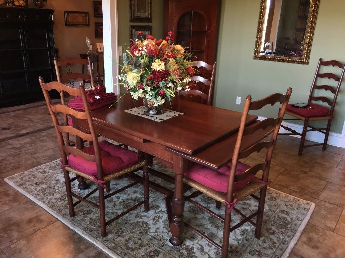 Dinging room suite with matching Ladder Back Chairs and features a pull out expandable table with burgundy cushions. There are six chairs including a host chair. Gorgeous floral adds a "WOW" to the table and chairs.  