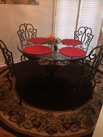GORGEOUS BLACK WROUGHT IRON AND GLASS TOP TABLE WITH 4 UPHOLSTERED CHAIRS
