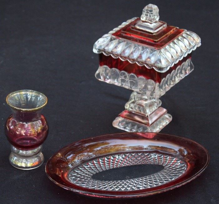 Ruby Glass Trio

Very pretty Ruby Glass. Nice variety. Lidded, footed candy dish is 8"t.

Oval dish is almost 9"l.

Small vase is 4"t. The paint is chipping on the bottom.  