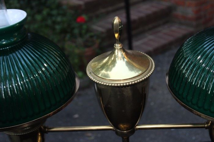 Vintage Student Lamp

Tested and working. Very well kept in a non-smoking home.

Measures 24"T and 27 1/2"W

Gold-colored metal lamp with two lights protruding from either side, decorative finial in center. Round, green glass lampshades on both sides with clear hurricane shade within. 