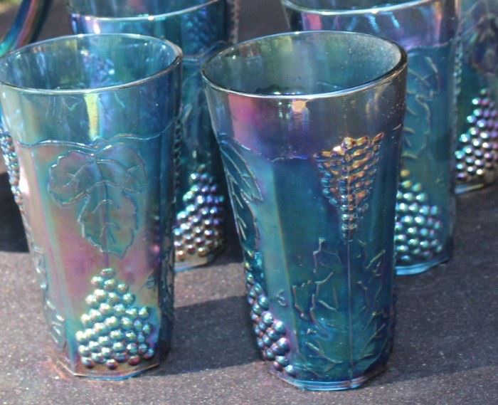 Carnival Glass Collect - Grape Pattern

Includes 8 tall glasses and one pitcher. No cracks or chips, very good condition. Features floral and grape textured impressions. Color has a metallic quality, subtle tones of purple, green and blue. Slightly transparent.
Glass measures: 5 3/4"T, 3 1/2" Diameter
Pitcher measures: 10 3/4"T, 6" Diameter