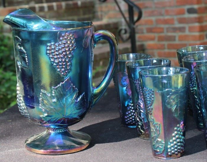 Carnival Glass Collect - Grape Pattern

Includes 8 tall glasses and one pitcher. No cracks or chips, very good condition. Features floral and grape textured impressions. Color has a metallic quality, subtle tones of purple, green and blue. Slightly transparent.
Glass measures: 5 3/4"T, 3 1/2" Diameter
Pitcher measures: 10 3/4"T, 6" Diameter