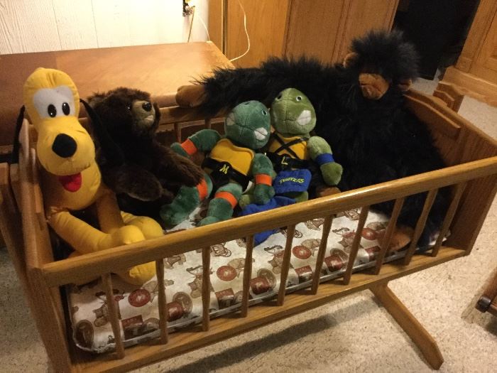 Goofy, Ninja turtles stuffed toys in hand-crafted wood cradle.