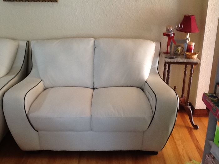 White leather with black trim love seat