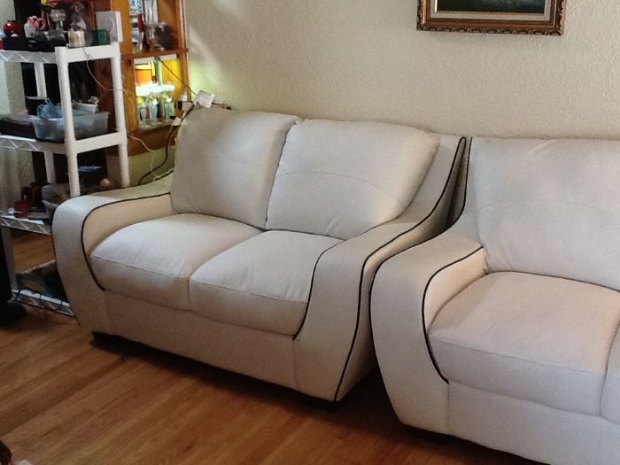 White leather with black trim love seat