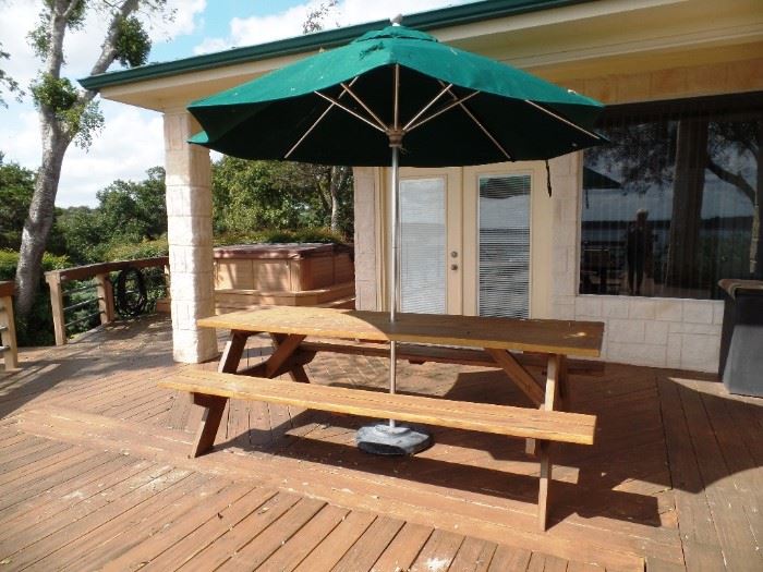 Long picnic table with attached benches and umbrella