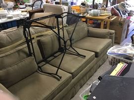 Two sofas in garage, wrought iron glass top table.