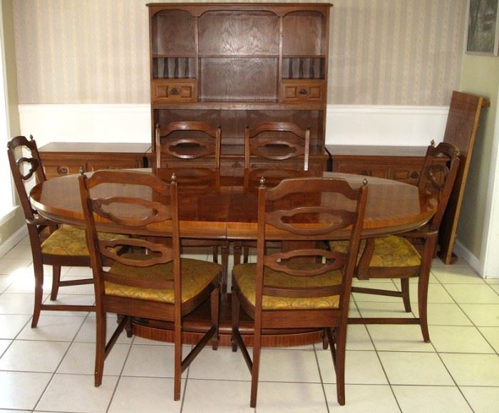 Oval Dining Room Table on Dual Column Base w/leaf shown on the right wall.  There are  4 Side and 2 Arm Chairs.  Pictured in the background is an open Hutch and 2 Lowboy 3-Drawer Chest.  All sold separately.