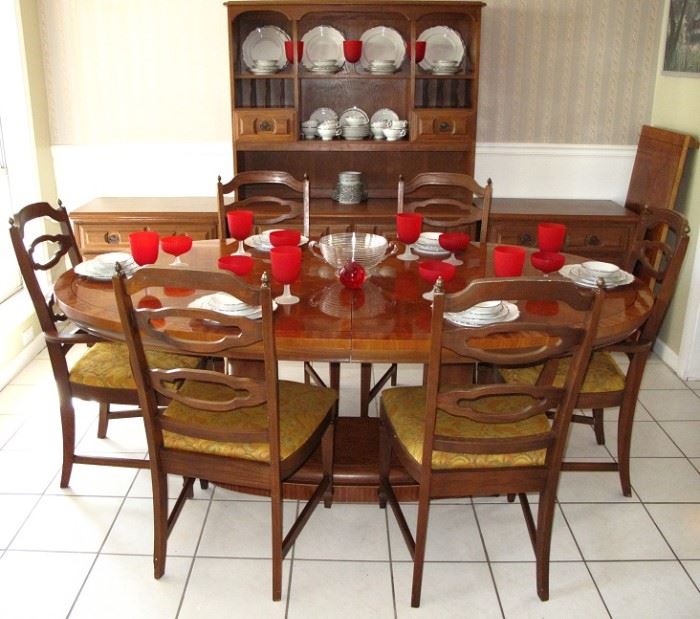 Oval Dining Room Table on Dual Column Base w/leaf shown on the right wall. Set with Bavarian China & Red Stemware  There are  4 Side and 2 Arm Chairs.  Pictured in the background is an open Hutch and 2 Lowboy 3-Drawer Chest.  All sold separately.