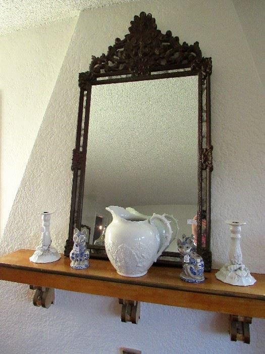 Carved wood mirror, English leaf pitcher, mosaic cat planter and candlestick, and Italian seashell-themed candlesticks.