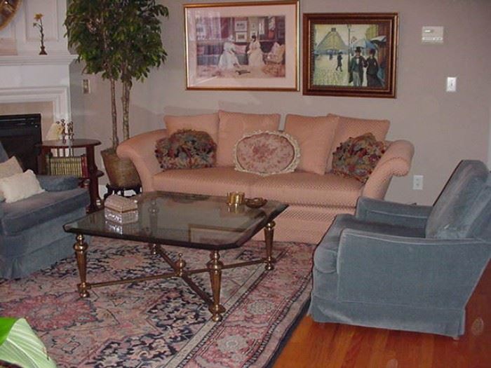 Fine uphostered sofa and chairs; room-sized Oriental rug; glass and brass coffee table