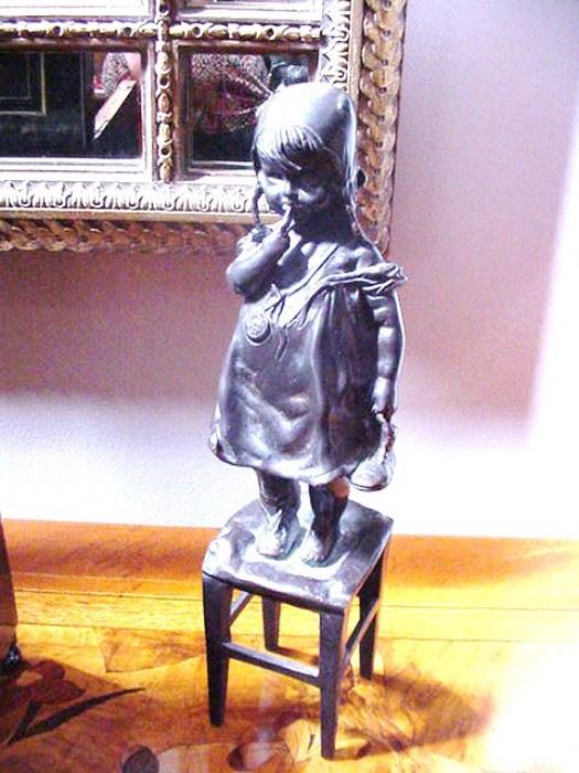 Bronze of a girl standing on a stool