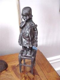 Bronze of little girl standing on a stool