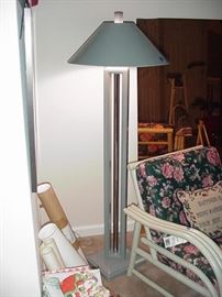 Tall metal floor lamp and rattan arm chair