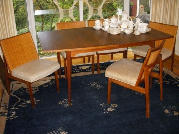 Danish modern table.  Table has 2 additional leaves. 5 Chairs with the table are labeled "Designed by George Nelson for Herman Miller"
