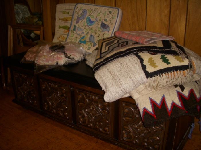 Storage chest with upholstered top displaying weavings
