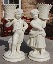 Belleek Irish Porcelain Basket Bearer Boy and Girl Mantle Candle Holders

Each measure 8 1/2"tall. A fabulous pair of Belleek Ireland spill vase parian china figurines. All Belleek porcelain is crafted and painted entirely by hand, with love and care, at the Belleek Studio, County Fermanagh, Ireland. Beautiful cream glaze parian china, 18th century dressed Welsh boy and girl holding a weave basket spill vase, perfect mantel figurines.