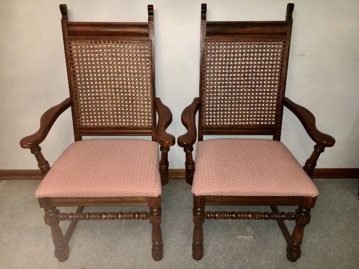 Matching pair of armed dining chairs with cane backs.