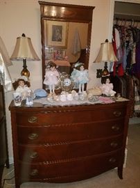 Mahogany dresser, table lamps, & part of an extensive doll collection. 