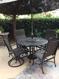 Complete metal patio table set with table, umbrella, two swivel rockers and two chairs, all matching and in great shape, top quality set