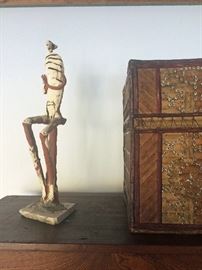 Detail of seated figure by contemporary sculptor Robert Brady, tribal art box embellished with cowrie shells