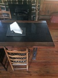 Detail of marble topped table with view of several of the mismatched antique ladder back chairs (sculpture on table NFS)