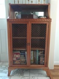 This is a cool piece. It's a small bookcase, with mirror at top and wire mesh to keep the help outta the liquor.