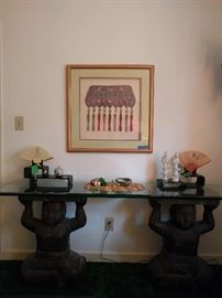 Pair of happy Buddhas, supporting a very thick, beveled glass top. Beautifully matted/shadowbox framed Asian textile.