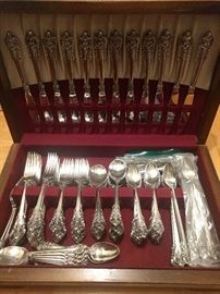 Two sets (Mother's & Grandmother's) Grand Baroque sterling flatware, by Wallace. What's to be said about girls who purchase the Grand Baroque pattern?                           This is Francis I with roses instead of fruit. Grande Baroque girls also have a sense of the dramatic. But they often also have a literary bent. That’s why you can buy a sterling silver bookmark in the Grande Baroque pattern. Grande Baroque girls often date boys whose families have the Acorn pattern. But they don’t marry them. It’s just a youthful rebellion.                                    This set weighs 14 1/2 lbs. & includes:                                                                    -11 cocktail forks                                                                      -18 luncheon knives                                                                   -17 dinner forks                                                                      -16 salad forks                                             
