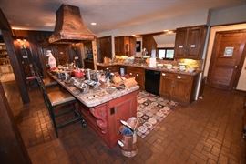 Gourmet Kitchen Complete with Leather Nailhead Hightop Chairs, Hammered Copper Hood Vent, Weathered Brass Horse Head Pot Rack and Gourmet Cookware