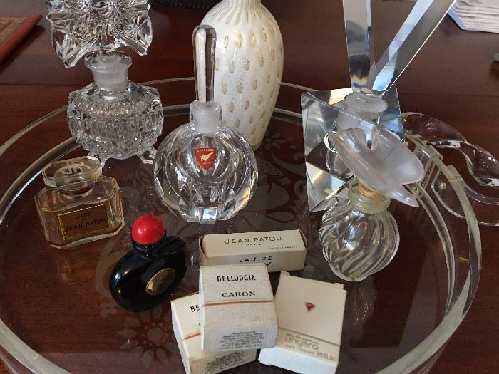 Assortment of perfume bottles on a lucite Dorothy Thorpe style tray.