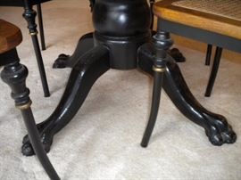 Antique claw foot oak table with black accent and four metal framed chairs with wicker seating