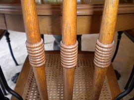 Antique claw foot oak table with black accent and four metal framed chairs with wicker seating