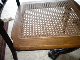 Antique claw foot oak table with black accent and four metal framed chairs with wicker seating
