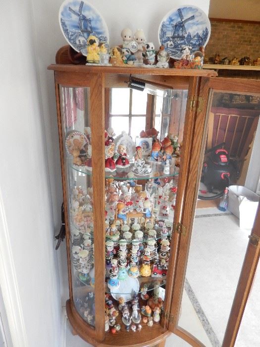 CURVED,LIGHTED CURIO CABINET FILLED WITH KURT ADLER HERSHEY CHARACTERS, ETC.
