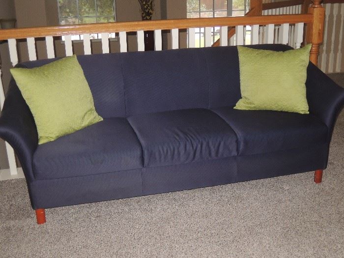 Dark blue, 3-cushion sofa.  Many, many throw pillows