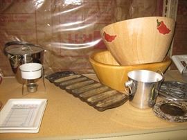 Cast iron blue corn muffin pans, butterwarmer, champagne buckets and trivets, wooden salad bowls, Eddy Fishs specialty trays