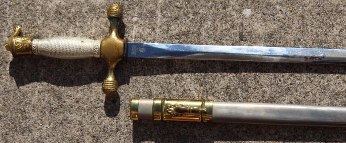 Authentic West Point Cadet Sword

Gold/silver colored cadet sword, eagle engravings on sword guard and pommel. Handle reads "Honor Country. USMA."
Grip is slightly loose. Very slight rust along outside of sheath. Blade of sword is decoratively marked "U.S.M.A."
Circa 1980-ish. Total length of 36" (3').