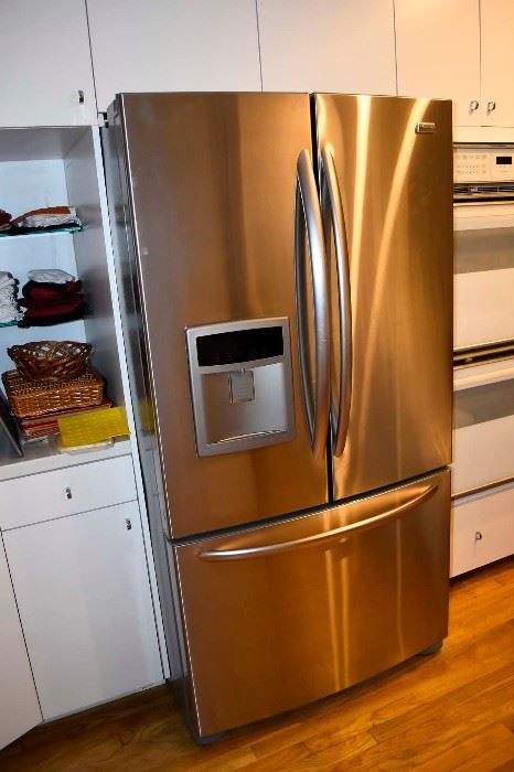 Kenmore stainless steel double door refrigerator with freezer door at bottom.
