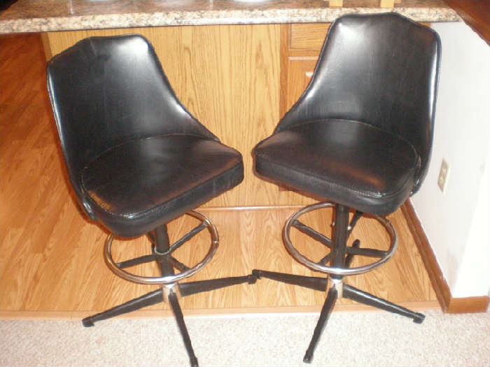 Two black vinyl bar stools, counter height.