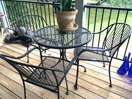 Patio bistro table and chairs, blue bottles.